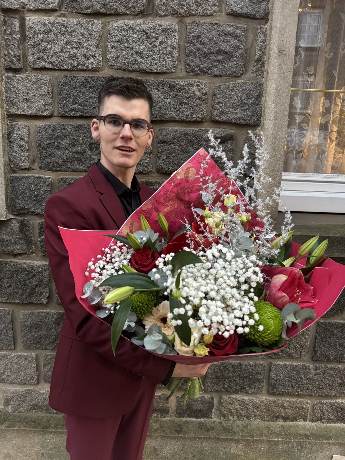 Benjamin, fondateur de L'Atelier de Benji, avec un bouquet